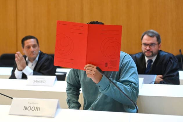 Der Angeklagte im Verhandlungssaal, verbirgt sein Gesicht hinter einem Schnellhefter. Hinten seine Anwaelte,Verteidiger. Urteil im Strafverfahren gegen Farhad Noori wegen Mordes u.a.(Seidlstrasse) am 06.08.2026 vor dem Oberlandesgericht Muenchen *** The defendant in the courtroom hides his face behind a binder; behind him are his attorneys. Verdict in the criminal trial against Farhad Noori for murder, among other charges, on Seidlstrasse on August 6, 2026, before the Munich Higher Regional Court