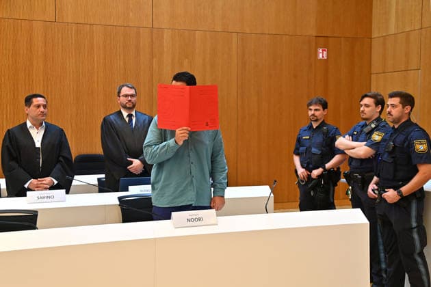 Der Angeklagte im Verhandlungssaal, verbirgt sein Gesicht hinter einem Schnellhefter.Hinten:seine Verteidiger RA Oemer SAHINCI, RA Johann BUND. Urteil im Strafverfahren gegen Farhad Noori wegen Mordes u.a.(Seidlstrasse) am 06.08.2026 vor dem Oberlandesgericht Muenchen *** The defendant in the courtroom hides his face behind a binder. Behind him are his defense attorneys, Oemer SAHINCI, Esq., and Johann BUND, Esq. Judgment in the criminal case against Farhad Noori for murder, among other charges, on Seidlstrasse on August 6, 2026, before the Munich Higher Regional Court