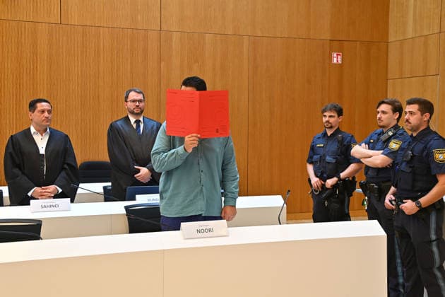 Der Angeklagte im Verhandlungssaal, verbirgt sein Gesicht hinter einem Schnellhefter.Hinten:seine Verteidiger RA Oemer SAHINCI, RA Johann BUND. Urteil im Strafverfahren gegen Farhad Noori wegen Mordes u.a.(Seidlstrasse) am 06.08.2026 vor dem Oberlandesgericht Muenchen *** The defendant in the courtroom hides his face behind a binder. Behind him are his defense attorneys, Oemer SAHINCI, Esq., and Johann BUND, Esq. Judgment in the criminal case against Farhad Noori for murder, among other charges, on Seidlstrasse on August 6, 2026, before the Munich Higher Regional Court