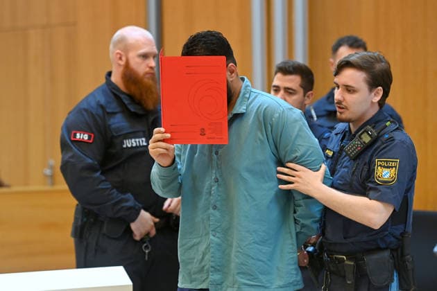 Der Angeklagte wird von Justizbeamten in den Verhandlungssaal gefuehrt. Urteil im Strafverfahren gegen Farhad Noori wegen Mordes u.a.(Seidlstrasse) am 06.08.2026 vor dem Oberlandesgericht Muenchen *** The defendant is escorted into the courtroom by court officers. The verdict in the criminal case against Farhad Noori for murder, among other charges, related to the Seidlstrasse incident will be handed down on August 6, 2026, at the Munich Higher Regional Court.