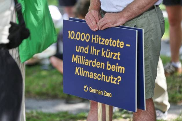 Berlin, Deutschland, 06.08.2026: Bundeskanzleramt: Klimabündnis fordert Hitzegipfel: Schild mit der Aufschrift: 10.000 Hitzetote - und ihr kürzt Milliarden beim Klimaschutz? *** Berlin, Germany, August 6, 2026 Federal Chancellery Climate Alliance Calls for Heat Summit: Sign Reading 10,000 Heat-Related Deaths, and You’re Cutting Billions from Climate Protection Copyright: xdtsxNachrichtenagenturx dts_129452