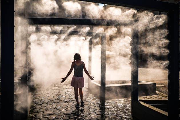 (260806) -- BUDAPEST, Aug. 6, 2026 -- A woman cools off under a misting system in Budapest, Hungary, Aug. 6, 2026. Hungarian authorities on Tuesday extended the country s highest-level heat alert until midnight on Friday as forecasts indicate the ongoing heatwave will continue across the country. (Photo by h Xinhua) HUNGARY-BUDAPEST-HEAT WAVE DavidxBalog 