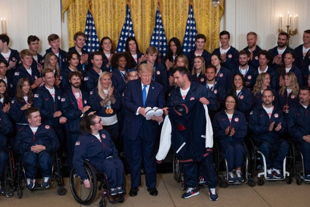 President Trump Hosts Team USA Olympians at White House United States President Donald J Trump is gifted a Team USA jacket and shoes in the East Room of the White House in Washington, DC, USA, on Thursday, August 6, 2026. President Trump is hosting a ceremony for Team USA Olympians who competed in the 2026 Olympic Winter Games in Italy. Credit: Aaron Schwartz Pool via CNP Washington District of Columbia United States  Copyright: xPool ABACAx