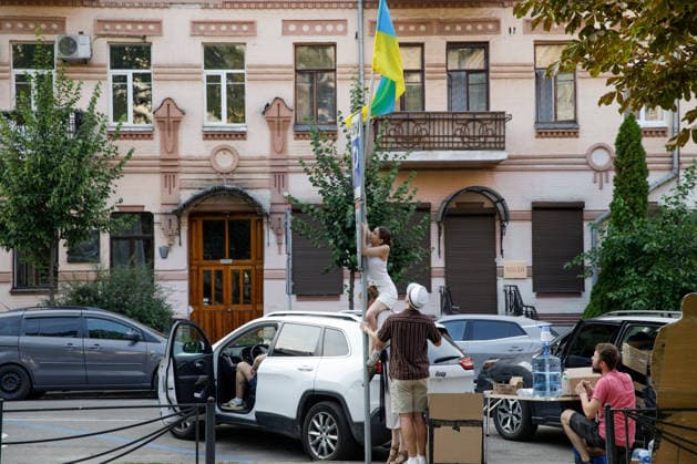 An activist installs a national flag on a road sign post during a peaceful protest against the dismissal of Mykhailo Fedorov from the post of Ukraine’s Defence Minister in Ivana Franka Square outside the Ivan Franko National Academic Drama Theatre, close to the Office of the President, Kyiv, Ukraine, August 6, 2026. Large-scale cardboard rallies in support of former Defence Minister Mykhailo Fedorov have been held in Kyiv and other cities across Ukraine for 22 consecutive days. On 14 July 2026, the Ukrainian Parliament accepted the resignation of Prime Minister Yuliia Svyrydenko, leading to the resignation of the Cabinet. On 15 July 2026, President Volodymyr Zelenskyy dismissed Defence Minister Mykhailo Fedorov, sparking widespread protes  Copyright: xMariannaxKotykx