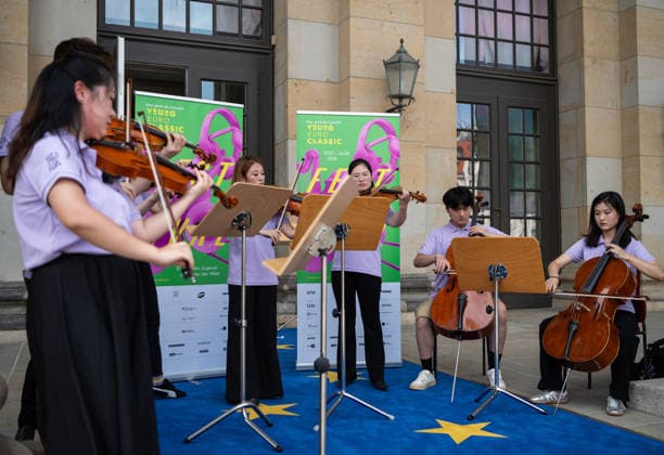 (260806) -- BERLIN, Aug. 6, 2026 -- Musicians from the Orchestra of the Zhejiang Conservatory of Music perform during a flash mob activity at the Konzerthaus Berlin in Berlin, Germany, Aug. 5, 2026. Orchestra of the Zhejiang Conservatory of Music took the stage on Wednesday at the Konzerthaus Berlin, delivered a captivating performance at the Young Euro Classic 2026. During its stay, the orchestra also staged a series of flash mob performances. ) GERMANY-BERLIN-CHINA-ORCHESTRA-PERFORMANCE ZhangxHaofu 
