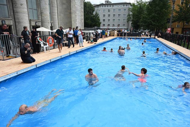 Temporary swimming pool opened in front of the Volksbuehne theatre in Berlin BERLIN, GERMANY - AUGUST 07: People swim and visit the newly opened Volksbad, a temporary public swimming pool installed in front of the Volksbuehne theatre at Rosa-Luxemburg-Platz in Berlin, Germany, on August 07, 2026. To mark the start of the Volksbuehne’s new artistic directorship, a temporary public swimming pool with a 25-meter swimming lane has been installed on the square for eight weeks. Volodymyr Sindieiev Anadolu Berlin Germany. Editorial use only. Please get in touch for any other usage.  Copyright: x2026xAnadoluxVolodymyrxSindieievx