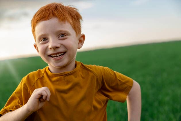 Cheerful boy with red hair runs across a green field model released, Symbolfoto, MBLF01323