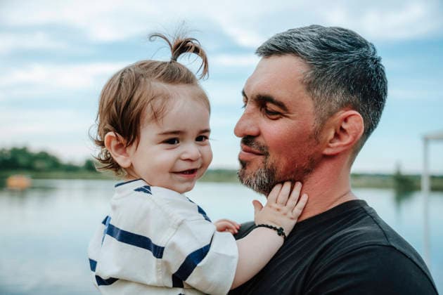 Father holds his smiling baby son by the pond in summer model released, Symbolfoto, NLAF00790