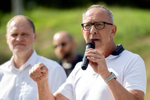 07.08.2026, Deutschland,Sachsen, Doberschau-Gaußig: Der AfD-Landtagsabgeordnete Frank Peschel (hinten) hat eine Protestkundgebung angekündigt am Maxam-Werk organisiert. Das Werk wurde vom Rüstungshersteller Czechoslovak Group (CSG) gekauft. Peschel will gegen die Militarisierung unseres Landes demonstrieren. Im Bild vorn der AfD-Vorsitzende Sachsens, Jörg Urban bei seiner Rede. *** August 7, 2026, Germany, Saxony, Doberschau-Gaußig: AfD state parliament member Frank Peschel (in the back) has announced a protest rally organized at the Maxam plant. The plant was purchased by the defense contractor Czechoslovak Group (CSG). Peschel wants to demonstrate against the militarization of our state. Pictured in the foreground is Jörg Urban, chair