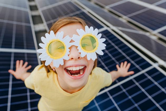 Happy girl wears daisy sunglasses near a solar panel outdoors model released, Symbolfoto property released, YTF05005