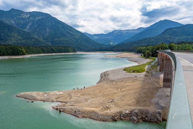 Der Wasserspiegel des Sylvensteinspeichers ist wegen anhaltender Trockenheit deutlich gesunken, breite Uferstreifen sind trocken gefallen, das Niedrigwasser sorgt für breite Kiesflächen, Bayerische Alpen, Lenggries, 7. August 2026 Deutschland, Lenggries-Fall, 7. August 2026, breite Kiesflächen am Ufer des Sylvensteinspeichers, die anhaltende Trockenheit hat den Wasserspiegel des Sylvensteinspeichers deutlich sinken lassen, breite Uferstreifen sind trocken gefallen, Niedrigwasser sorgt für einen breiten Kiesstrand, Blick von der Brücke, künstlicher Speichersee in den Bayerischen Voralpen bei Lenggries, Wasserspeicher zur Regulierung der Isar, Hochsommer, heißer Sommertag, Freitagnachmittag, Landkreis Bad Tölz-Wolfratshausen, Oberbay