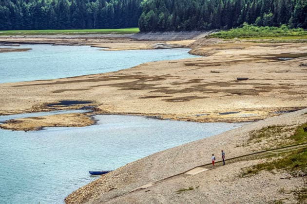 Der Wasserspiegel des Sylvensteinspeichers ist wegen anhaltender Trockenheit deutlich gesunken, breite Uferstreifen sind trocken gefallen, das Niedrigwasser sorgt für breite Kiesflächen, Bayerische Alpen, Lenggries, 7. August 2026 Deutschland, Lenggries-Fall, 7. August 2026, breite Kiesflächen am Ufer des Sylvensteinspeichers, die anhaltende Trockenheit hat den Wasserspiegel des Sylvensteinspeichers deutlich sinken lassen, breite Uferstreifen sind trocken gefallen, Niedrigwasser sorgt für einen breiten Kiesstrand, Spaziergänger am Ufer, künstlicher Speichersee in den Bayerischen Voralpen bei Lenggries, Wasserspeicher zur Regulierung der Isar, Hochsommer, heißer Sommertag, Freitagnachmittag, Landkreis Bad Tölz-Wolfratshausen, Oberba