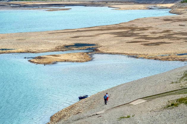 Der Wasserspiegel des Sylvensteinspeichers ist wegen anhaltender Trockenheit deutlich gesunken, breite Uferstreifen sind trocken gefallen, das Niedrigwasser sorgt für breite Kiesflächen, Bayerische Alpen, Lenggries, 7. August 2026 Deutschland, Lenggries-Fall, 7. August 2026, breite Kiesflächen am Ufer des Sylvensteinspeichers, die anhaltende Trockenheit hat den Wasserspiegel des Sylvensteinspeichers deutlich sinken lassen, breite Uferstreifen sind trocken gefallen, Niedrigwasser sorgt für einen breiten Kiesstrand, Spaziergänger am Ufer, künstlicher Speichersee in den Bayerischen Voralpen bei Lenggries, Wasserspeicher zur Regulierung der Isar, Hochsommer, heißer Sommertag, Freitagnachmittag, Landkreis Bad Tölz-Wolfratshausen, Oberba