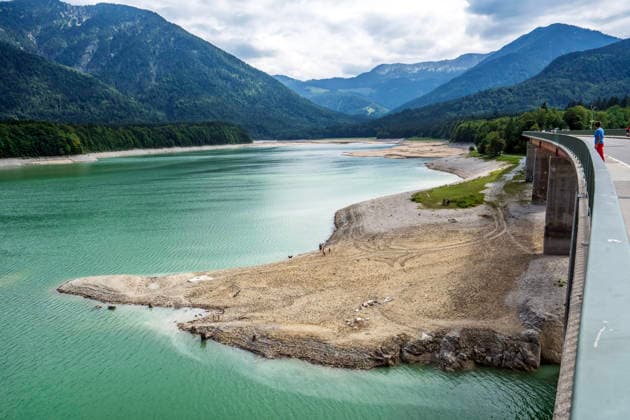 Der Wasserspiegel des Sylvensteinspeichers ist wegen anhaltender Trockenheit deutlich gesunken, breite Uferstreifen sind trocken gefallen, das Niedrigwasser sorgt für breite Kiesflächen, Bayerische Alpen, Lenggries, 7. August 2026 Deutschland, Lenggries-Fall, 7. August 2026, breite Kiesflächen am Ufer des Sylvensteinspeichers, die anhaltende Trockenheit hat den Wasserspiegel des Sylvensteinspeichers deutlich sinken lassen, breite Uferstreifen sind trocken gefallen, Niedrigwasser sorgt für einen breiten Kiesstrand, Blick von der Brücke, künstlicher Speichersee in den Bayerischen Voralpen bei Lenggries, Wasserspeicher zur Regulierung der Isar, Hochsommer, heißer Sommertag, Freitagnachmittag, Landkreis Bad Tölz-Wolfratshausen, Oberba