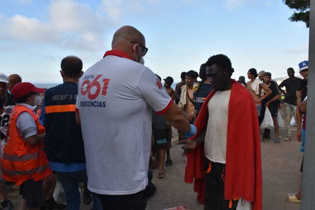 Red Cross and INGESA Provide Care to Migrants at Trampolín Beach Hundreds of migrants receive medical care from INGESA professionals and Red Cross volunteers at Trampolín Beach on August 7, 2026, in Ceuta, Spain. Professionals from the National Institute of Health Management (INGESA) and Red Cross volunteers are providing medical care and distributing food to hundreds of migrants under the coordination of the National Police riot squad. AUGUST 8, 2026. Gabriela Sardá Nún. Ceuta, Spain.  Copyright: xGabrielaxSardaxNunezx 7705740
