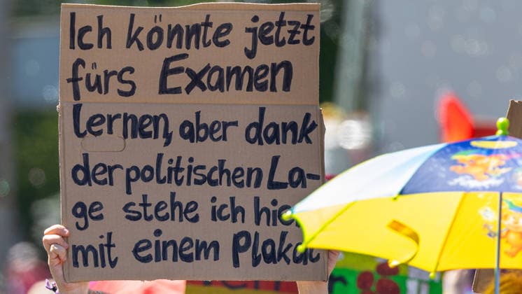 CSD Nürnberg 2026 Nürnberg Pride Week, Nürnberg, 08.08.2026 Ein handbeschriftetes Pappschild mit einer politisch-ironischen Botschaft zum Examen wird bei der Parade des Christopher Street Day durch die Nürnberger Innenstadt hochgehalten. Im Hintergrund ist ein bunter Sonnenschirm in Gelb und Blau zu sehen. Nürnberg Bayern Deutschland *** CSD Nuremberg 2026 Nuremberg Pride Week, Nuremberg, August 8, 2026 A handwritten cardboard sign with a politically ironic message about exams is held aloft during the Christopher Street Day parade through downtown Nuremberg. In the background, a colorful yellow and blue parasol can be seen. Nuremberg, Bavaria, Germany 20260808-1V9A6771-M4000