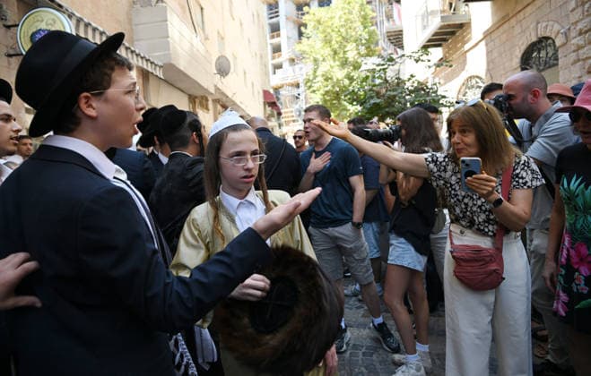 Secular Israelis argue with Ultra-Orthodox Jews protesting against Cafe Basimta for being open on the Jewish Sabbath, Saturday, in central Jerusalem, August 8, 2026. Few cafes and restaurants are open from dusk on Friday until dusk on Saturday in observance of the Sabbath in Jerusalem.  JER2026080815 DEBBIExHILL