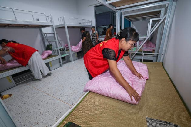 (260808) -- WUYI, Aug. 8, 2026 -- Volunteers make beds at a temporary shelter in Datian Township, Wuyi County, Jinhua City, east China s Zhejiang Province, Aug. 8, 2026. The shelter has received 92 villagers, offering health check, meal delivery and other daily service. Coastal areas of eastern China were bracing for strong winds and torrential rain as Typhoon Dolphin approached, prompting authorities to recall fishing boats, suspend ferry services and prepare for evacuations. China s meteorological authority on Saturday upgraded its emergency response for Dolphin to Level III and raised the typhoon warning from yellow to orange. ) CHINA-ZHEJIANG-TYPHOON DOLPHIN-PREVENTION (CN) XuxYu 