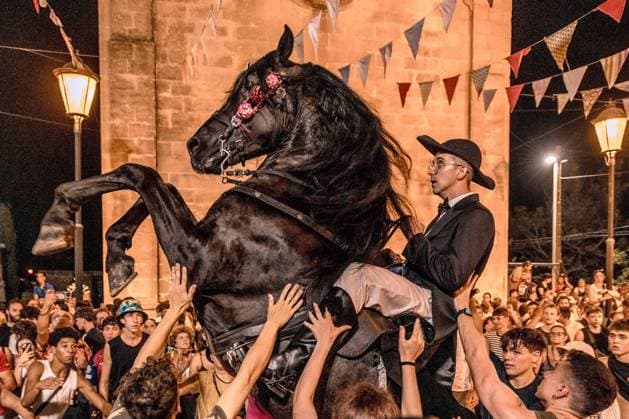 August 8, 2026, Llucmacanes, Menorca Balearic Islands, Spain: A caixer, or horse rider, rears his horse amid a cheering crowd during the traditional Jaleo at the Sant Gaieta Festival in Llucmacanes Llucmacanes Spain - ZUMAo105 20260808_fap_o105_017 Copyright: xMatthiasxOesterlex