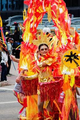 August 8, 2026, Edmonton, Alberta, Canada: Mas Band member pulls her costume on wheels through downtown Edmonton during the Cariwest Parade on day 2 of the Cariwest Festival..Western Canada s largest Caribbean Festival, Cariwest, held its annual parade as part of its 42nd year of festivities. The Parade Mas Bands represent the various Caribbean various Islands and are dressed in brightly colored costumes, some of which can weigh up to 200 lbs, requiring wheels to support the weight. Edmonton Canada - ZUMAs197 20260808_aaa_s197_222 Copyright: xRonxPalmerx
