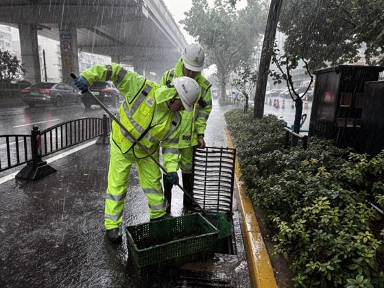 (260809) -- SHANGHAI, Aug. 9, 2026 -- Workers clean a drain grate on a road in Xuhui District of Shanghai, east China, Aug. 9, 2026. Shanghai experienced strong winds and rainfalls on Sunday as Typhoon Dolphin approached, with the typhoon s impact expected to last until Aug. 11. China s national observatory on Sunday activated a red alert -- the highest level in the country s typhoon warning system -- as Typhoon Dolphin approaches. Typhoon Dolphin is forecast to make landfall along the country s east coast from Zhoushan in Zhejiang Province to Fuding in Fujian Province, according to the National Meteorological Center (NMC). (Photo by Xinhua) CHINA-SHANGHAI-TYPHOON DOLPHIN-IMPACT (CN) WeixQingfeng 