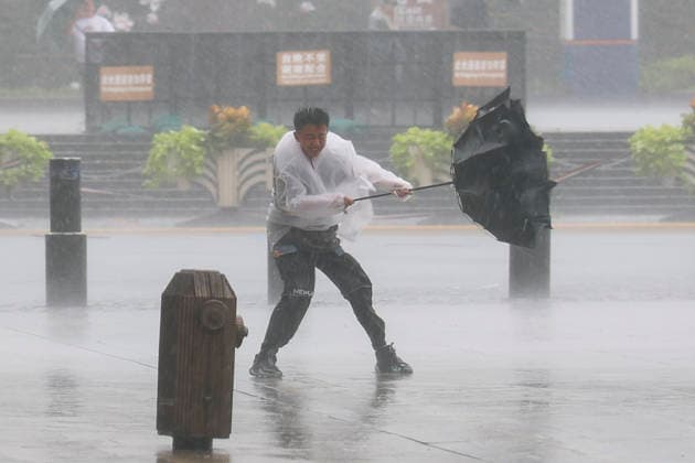 News Bilder des Tages (260809) -- SHANGHAI, Aug. 9, 2026 -- A man holds tightly onto an umbrella that is blown open by the wind amid rain at Huangpu District of Shanghai, east China, on Aug. 9, 2026. China s eastern metropolis Shanghai issued its highest rainstorm alert Sunday over rising risks of urban waterlogging brought by Typhoon Dolphin, the 13th typhoon of the year that has a great impact on the country s coastal regions. China s national observatory on Sunday activated a red alert -- the highest level in the country s typhoon warning system -- as Typhoon Dolphin approaches. Typhoon Dolphin is forecast to make landfall along the country s east coast from Sanmen in Zhejiang Province to Fuding in Fujian Province around Sunday evening to the early hou 