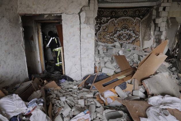 Russian Drone Strike On Residential Building - Kharkiv A rescue worker in high-visibility gear searches through rubble inside a severely damaged residential apartment, with a decorative carpet still hanging on the wall above the debris, in Kharkiv, Ukraine, on August 9, 2026. drone strikes hit multi-story residential buildings in the Saltivka district on the morning of August 9, killing two people and wounding at least 27, according to Kharkiv Regional Military Administration. Photo by Yevhen Titov ABACAPRESS.COM Kharkiv Kharkiv Oblast Ukraine  Copyright: xTitovxYevhen ABACAx