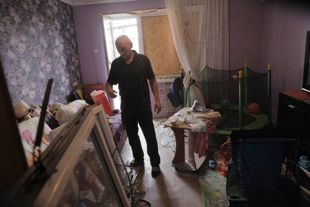Russian Drone Strike On Residential Building - Kharkiv A man walks through a severely damaged residential apartment with purple-patterned wallpaper, boarded windows, debris scattered across the floor, and overturned furniture in Kharkiv, Ukraine, on August 9, 2026. The apartment sustained structural damage from a drone strike that struck a multi-story residential building in the Saltivka district early that morning, killing two people and wounding dozens more. Photo by Yevhen Titov ABACAPRESS.COM Kharkiv Kharkiv Oblast Ukraine  Copyright: xTitovxYevhen ABACAx