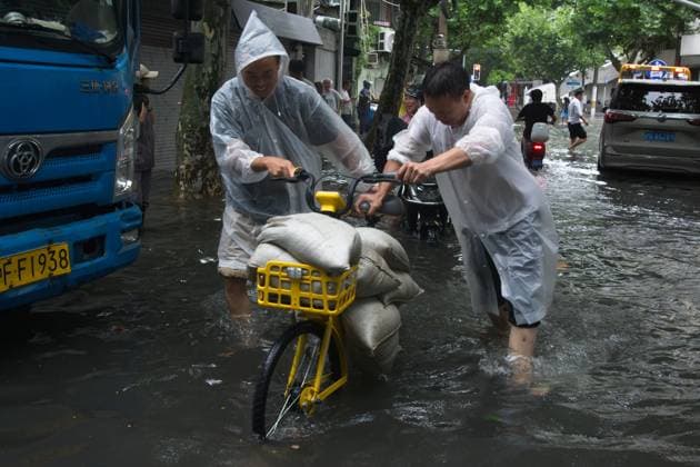 Typhoon Dolphin Arrives To Shanghai Two men carry extra sandbags for residents living near the flooding area in a neighborhood near Changle Road in Shanghai, China, as Typhoon Dolphin approaches the city. shanghai China  Copyright: xYingxTangx originalFilename: tang-typhoond260808_npoWs.jpg
