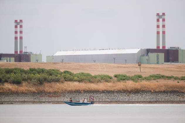 Hungarian nuclear power plant Paks runs on minimum due to water shortage PAKS, HUNGARY - AUGUST 9: People ride a motorboat on the low waters of the river Danube with the Paks Nuclear Power Plant visible in the background, in Paks, Hungary on August 9, 2026. The plant is currently operating with only one of its four reactors at minimum output, an unprecedented situation in its nearly 40-year history, as historically low Danube water levels caused by severe drought have constrained the plant’s cooling capacity. Robert Nemeti Anadolu Paks Hungary. Editorial use only. Please get in touch for any other usage.  Copyright: x2026xAnadoluxRobertxNemetix
