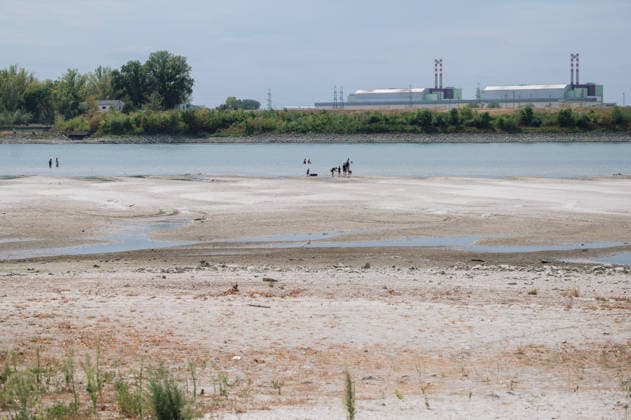 Hungarian nuclear power plant Paks runs on minimum due to water shortage PAKS, HUNGARY - AUGUST 9: People cool off in the extremely low waters of the Danube near Paks, Hungary, with the Paks Nuclear Power Plant visible in the background on August 9, 2026. The plant is currently operating with only one of its four reactors at minimum output, an unprecedented situation in its nearly 40-year history, as historically low Danube water levels caused by severe drought have constrained the plant’s cooling capacity. Robert Nemeti Anadolu Paks Hungary. Editorial use only. Please get in touch for any other usage.  Copyright: x2026xAnadoluxRobertxNemetix