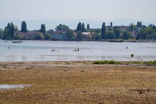 Bodensee bei Bottighofen (Kanton Thurgau), Schweiz: Weit zurückgezogener Wasserstand legt große Kies- und Uferflächen frei. Totale, Niedrigwasser, Bodenseeufer, Kiesbank, Flachwasserzone, Trockenheit, Dürre, Klimawandel, Hitze, Wetterextreme, Wasserknappheit, Umwelt, Natur, Badegäste, Stand-up-Paddling, Freizeit, Wassersport, Segelboot, Sommer, Alpenpanorama, Bodensee, Schweiz, Symbolbild. *** Lake Constance near Bottighofen, Canton of Thurgau, Switzerland; Water levels have receded significantly, exposing large areas of gravel and shoreline; Total, low water, Lake Constance shoreline, gravel bank, shallow water zone, drought, climate change, heat, extreme weather, water scarcity, environment, nature, swimmers, stand-up paddleboard Copyright: xJOERANxSTEINSIEKx
