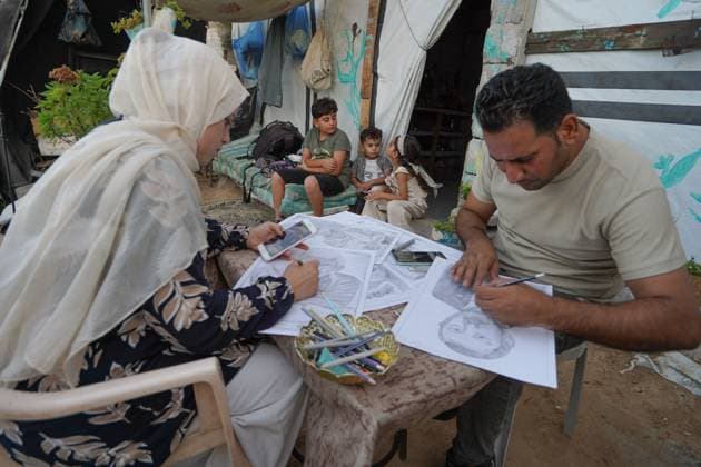 August 9, 2026, Gaza City, Palestine: Palestinian artist NADIA ABU ISSA (left) and another artist work on charcoal drawings depicting the hardships faced by civilians during the war in Gaza, including food and water shortages, displacement, and insecurity. Abu Issa says her artwork documents the daily realities experienced by Palestinians and seeks to preserve those experiences through art. Among her recent works is a portrait of Turkish President Recep Tayyip Erdogan, which she says she created as a gesture of appreciation for Turkey s support for Palestinians. Gaza City Palestine - ZUMAq101 20260809_zna_q101_137 Copyright: xRamzixAbuxAmerx