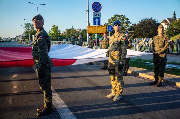 Poland s armed forces rehearse for the national Armed Forces Day parade in Warsaw, Poland - 9 Aug 2026 Soldiers hold the Polish flag before the beginning of the parade rehearsal. Early in the morning of 9th August, Poland s armed forces, and those of allies stationed in the country, take part in a rehearsal in preparation for a parade on National Armed Forces Day on the 15th August. Soldiers muster as the sun rises over the Vistula River and march past grandstands prepared for dignitaries. The soldiers were followed by mechanised divisions travelling in tanks and a variety of armoured vehicles. Afterwards, Secretary of State in the Ministry of Defence, Pawel Bejda addresses a post-rehearsal press conference, where he is accompanied by the C Copyright: xNeilxMiltonx xSOPAxImagesx NSM2026165G0809-L1002358_5000_300dpi