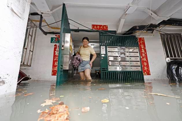 SHANGHAI, CHINA - AUGUST 09: A resident wades through floodwaters in a residential area on August 9, 2026 in Shanghai, China. The Shanghai Meteorological Observatory upgraded the rainstorm warning signal for the central urban area from orange to red at 10:30 a.m. due to the impact of Typhoon Dolphin.  Copyright: xChinaxNewsxServicex 111658975276