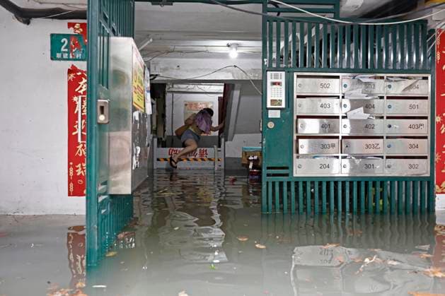 SHANGHAI, CHINA - AUGUST 09: A resident wades through floodwaters in a residential area on August 9, 2026 in Shanghai, China. The Shanghai Meteorological Observatory upgraded the rainstorm warning signal for the central urban area from orange to red at 10:30 a.m. due to the impact of Typhoon Dolphin.  Copyright: xChinaxNewsxServicex 111658975202