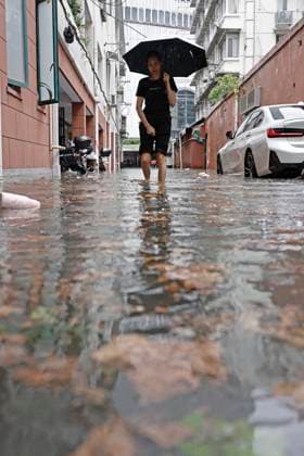 SHANGHAI, CHINA - AUGUST 09: A resident wades through floodwaters in a residential area on August 9, 2026 in Shanghai, China. The Shanghai Meteorological Observatory upgraded the rainstorm warning signal for the central urban area from orange to red at 10:30 a.m. due to the impact of Typhoon Dolphin.  Copyright: xChinaxNewsxServicex 111658975275