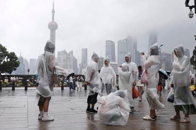 SHANGHAI, CHINA - AUGUST 09: Tourists wearing raincoats experience strong winds on the Bund on August 9, 2026 in Shanghai, China. The Shanghai Meteorological Observatory upgraded the rainstorm warning signal for the central urban area from orange to red at 10:30 a.m. due to the impact of Typhoon Dolphin.  Copyright: xChinaxNewsxServicex 111658975321