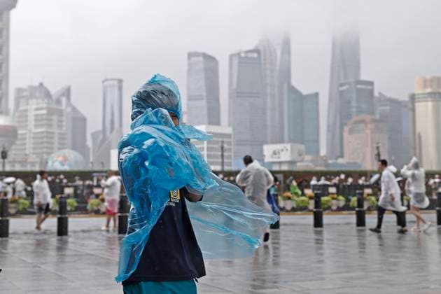 SHANGHAI, CHINA - AUGUST 09: A child wearing a raincoat experiences strong winds on the Bund on August 9, 2026 in Shanghai, China. The Shanghai Meteorological Observatory upgraded the rainstorm warning signal for the central urban area from orange to red at 10:30 a.m. due to the impact of Typhoon Dolphin.  Copyright: xChinaxNewsxServicex 111658975339