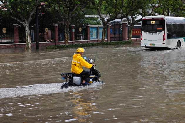 SHANGHAI, CHINA - AUGUST 09: A delivery rider wades through flooded waters on Lingling Road as Typhoon Dolphin brings heavy rain and strong winds to the city on August 9, 2026 in Shanghai, China.  Copyright: xVCGx 111659005860