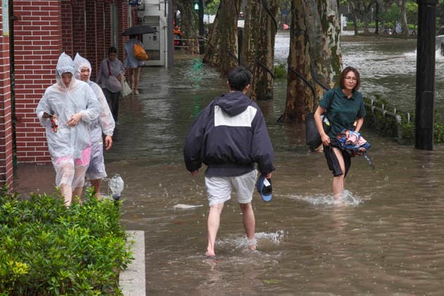 SHANGHAI, CHINA - AUGUST 09: Residents wade through flooded streets on Lingling Road as Typhoon Dolphin brings heavy rainfall on August 9, 2026 in Shanghai, China. The city experienced strong winds and widespread waterlogging due to the typhoon.  Copyright: xVCGx 111659005862