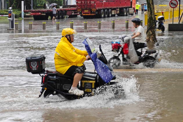 SHANGHAI, CHINA - AUGUST 09: A delivery rider wades through floodwaters on Lingling Road as Typhoon Dolphin brings heavy rainfall to the city on August 9, 2026 in Shanghai, China.  Copyright: xVCGx 111659005868