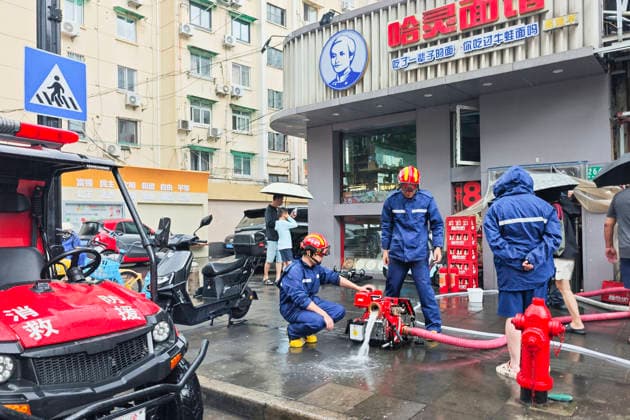 SHANGHAI, CHINA - AUGUST 09: Firefighters conduct water drainage operations at a flooded restaurant on August 9, 2026 in Shanghai, China. The city experienced heavy rain and strong winds brought by Typhoon Dolphin.  Copyright: xVCGx 111659005874