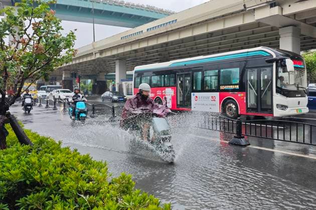 SHANGHAI, CHINA - AUGUST 09: A cyclist rides through floodwaters caused by heavy rain brought by Typhoon Dolphin on August 9, 2026 in Shanghai, China. The city was impacted by the typhoon, resulting in strong winds and significant rainfall.  Copyright: xVCGx 111659005854