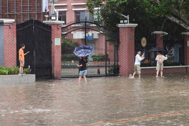 SHANGHAI, CHINA - AUGUST 09: Residents wade through floodwaters on Lingling Road as Typhoon Dolphin brings heavy rainfall to the city on August 9, 2026 in Shanghai, China. The typhoon has caused significant waterlogging in various parts of the metropolis.  Copyright: xVCGx 111659005858