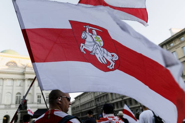 August 9, 2026, Warsaw, Poland: A man holds a Belarusian white-red-white flag during an evening rally marking the sixth anniversary of the August 2020 presidential election in Belarus. An evening gathering marking the sixth anniversary of the August 2020 presidential election in Belarus was held near the Nicolaus Copernicus Monument in central Warsaw, bringing together leaders of Belarusian democratic forces, public figures and activists, as well as several hundred participants. Warsaw Poland  - ZUMAs197 20260809_aaa_s197_112 Copyright: xVolhaxShukailax