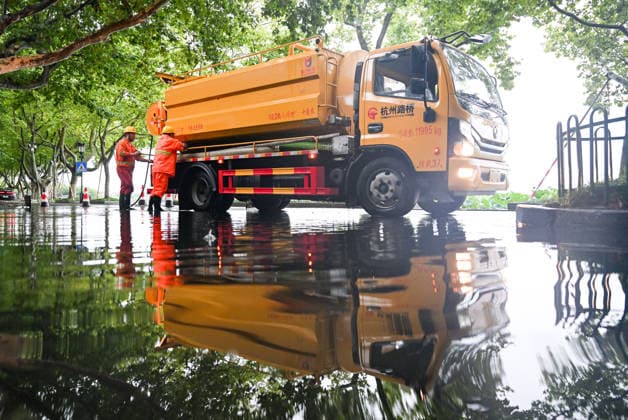 HANGZHOU, CHINA - AUGUST 10: Staff clear standing water from a road near West Lake on August 10, 2026 in Hangzhou, Zhejiang Province of China. Damaged construction facilities, fallen trees and flooded roads were reported in Hangzhou as the city was affected by Typhoon Dolphin , the 13th typhoon of the year.  Copyright: xChinaxNewsxServicex 111659086929