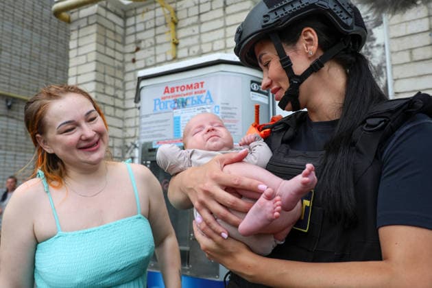 A State Emergency Service psychologist holds a baby evacuated from a 10-storey apartment block in the Saltivskyi district hit by a Russian S8000 Banderol cruise missile, Kharkiv, Ukraine, August 9, 2026. As a result of the terrorist attack, the seventh to tenth floors were destroyed. At present, three people are confirmed dead and 37 others injured. (Photo by Viacheslav Madiievskyi Ukrinform) Russian Banderol missile strikes apartment block in Kharkiv  Copyright: xViacheslavxMadiievskyix