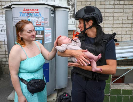 A State Emergency Service psychologist holds a baby evacuated from a 10-storey apartment block in the Saltivskyi district hit by a Russian S8000 Banderol cruise missile, Kharkiv, Ukraine, August 9, 2026. As a result of the terrorist attack, the seventh to tenth floors were destroyed. At present, three people are confirmed dead and 37 others injured. (Photo by Viacheslav Madiievskyi Ukrinform) Russian Banderol missile strikes apartment block in Kharkiv  Copyright: xViacheslavxMadiievskyix