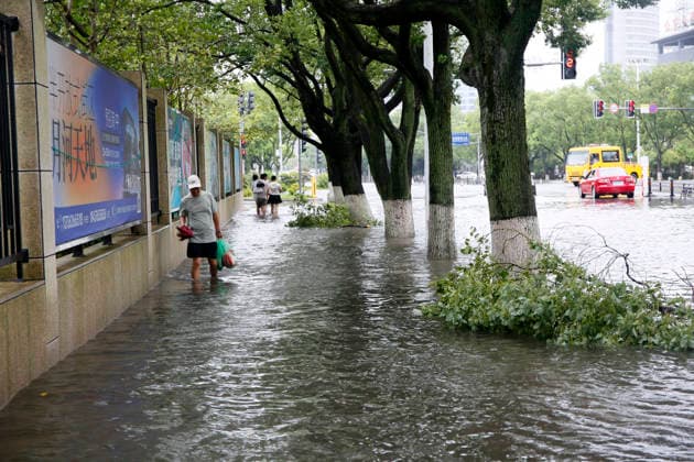 WENLING, CHINA - AUGUST 10: A resident walks through flooded street on August 10, 2026 in Wenling, Zhejiang Province of China. Heavy rainfall brought by Typhoon Dolphin caused severe waterlogging on roads and affecting residents travel. Typhoon Dolphin, the 13th typhoon of the year, made landfall at Yuhuan of Taizhou City, east China s Zhejiang Province, at around 5:30 p.m. on August 9.  Copyright: xVCGx 111659097427